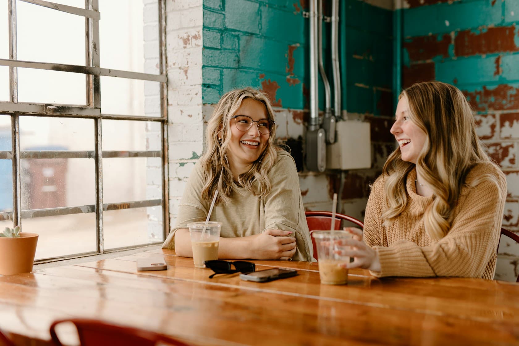 Two friends talking in a sunlit café